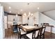 Open-concept dining area with a large wooden table, seating for eight, and modern lighting at 9804 Rosalee Peak St, Littleton, CO 80125