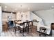 Open-concept dining area with a large wooden table, seating for eight, and modern lighting at 9804 Rosalee Peak St, Littleton, CO 80125