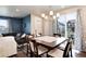 Bright dining area connected to the living room, featuring a modern chandelier and seating for six at 9804 Rosalee Peak St, Littleton, CO 80125