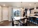 Bright dining area with sliding glass door, modern lighting, and seating for six guests at 9804 Rosalee Peak St, Littleton, CO 80125