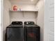 Modern laundry room features front load washer and dryer with shelf storage above at 9804 Rosalee Peak St, Littleton, CO 80125