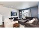 Comfortable living room featuring modern decor, a large sectional sofa, and a mounted flatscreen TV at 9804 Rosalee Peak St, Littleton, CO 80125