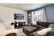 Comfortable living room featuring modern decor, a large sectional sofa, and a mounted flatscreen TV at 9804 Rosalee Peak St, Littleton, CO 80125