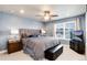 A comfortable main bedroom boasts a ceiling fan, large bed with decorative pillows and bright window at 9804 Rosalee Peak St, Littleton, CO 80125