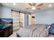 Relaxing main bedroom with bright window, ceiling fan, and an en suite bathroom accessible via sliding door at 9804 Rosalee Peak St, Littleton, CO 80125