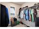 A walk-in closet offers ample hanging space and shelving, complemented by a window for natural light at 9804 Rosalee Peak St, Littleton, CO 80125