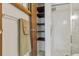 Bathroom featuring a tiled shower with sliding glass door and linen shelving at 13606 E Bates Ave # 304, Aurora, CO 80014
