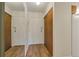 Entryway with a mirrored wall and wooden closet doors, featuring modern wood flooring at 13606 E Bates Ave # 304, Aurora, CO 80014