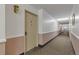 A carpeted hallway showing the entrance to the apartment, highlighted by a vintage light fixture at 13606 E Bates Ave # 304, Aurora, CO 80014
