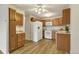 Efficient kitchen with wood cabinets, white appliances, and a ceiling fan for added comfort at 13606 E Bates Ave # 304, Aurora, CO 80014
