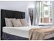 Bright bedroom with a comfortable bed, soft lighting, and a view of the neighborhood at 2281 Vaughn # 104A, Aurora, CO 80014