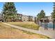 Community area with grassy lawn, pool, and mature trees surrounding the property at 2281 Vaughn # 104A, Aurora, CO 80014