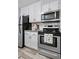 Updated kitchen with stainless steel appliances, white cabinets, and granite countertops at 2281 Vaughn # 104A, Aurora, CO 80014
