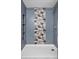 Modern tiled shower stall, complete with tiled accent wall and shower accessories at 2281 Vaughn # 104A, Aurora, CO 80014