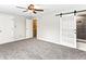Spacious carpeted bedroom featuring access to an ensuite bathroom via a modern sliding barn door at 421 E Highline Cir, Centennial, CO 80122