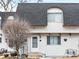 Charming townhome featuring a gray roof and stucco exterior with a quaint front door and manicured landscaping at 421 E Highline Cir, Centennial, CO 80122