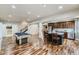 Open basement with a kitchen, billiards table, and hardwood floors, perfect for entertaining at 22475 E Hidden Trail Dr, Parker, CO 80138