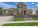 Charming two-story home with stone accents, manicured lawn, and covered driveway at 22475 E Hidden Trail Dr, Parker, CO 80138