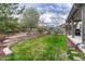 Backyard with a stone retaining wall, a small lawn, and access to the covered patio at 2618 Bellavista St, Castle Rock, CO 80109