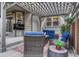 Covered outdoor patio area features comfortable seating, a TV, and a pergola covered with string lights at 2618 Bellavista St, Castle Rock, CO 80109