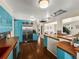 Bright, retro kitchen boasts blue cabinets, stainless steel appliances, and hardwood floors at 2348 W Ford Pl, Denver, CO 80223