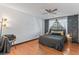 Comfortable bedroom with hardwood floors, designer wallpaper accent wall, and a ceiling fan at 6680 E Mississippi Ave # 3, Denver, CO 80224