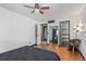 Bedroom with hardwood floors, ceiling fan, and closet with sliding barn door for extra storage at 6680 E Mississippi Ave # 3, Denver, CO 80224