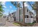 Inviting two-story townhouse featuring a grey exterior, white trim, and private fenced front yard under a sunny blue sky at 6680 E Mississippi Ave # 3, Denver, CO 80224