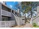 Exterior view of a two-story townhouse with a white picket fence, staircase, and second-story balcony at 6680 E Mississippi Ave # 3, Denver, CO 80224