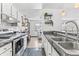 Well-lit kitchen featuring stainless steel appliances, black countertops, and modern fixtures at 6680 E Mississippi Ave # 3, Denver, CO 80224