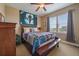 Cozy bedroom with sports themed art, window, ceiling fan and a comfortable bed with wood frame at 7635 Weaver Cir, Castle Rock, CO 80104