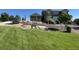 Front yard with lush green grass and mature trees providing excellent curb appeal at 7635 Weaver Cir, Castle Rock, CO 80104