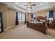 Spacious main bedroom with tray ceiling, a ceiling fan, large windows and luxurious furniture at 7635 Weaver Cir, Castle Rock, CO 80104