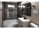 Stylish bathroom featuring grey tile, updated vanity, and modern fixtures at 1568 Verbena St, Denver, CO 80220