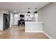 Bright kitchen with stainless steel appliances, island with seating, and contemporary lighting at 1568 Verbena St, Denver, CO 80220