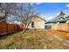 A view of backyard landscaping, new wood fence, grass, and stone walkway to the back door at 3196 S Logan St, Englewood, CO 80113