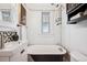 Bright bathroom with a clawfoot tub, modern vanity, and decorative black and white geometric tiles at 3196 S Logan St, Englewood, CO 80113