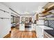 Open-concept kitchen flowing into dining area, featuring stainless steel appliances and white cabinets at 3196 S Logan St, Englewood, CO 80113