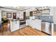 Stylish kitchen with white cabinets, patterned backsplash, and stainless steel appliances at 3196 S Logan St, Englewood, CO 80113
