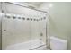 Tiled bathtub with sliding glass door and fixtures at 7852 S Logan St, Littleton, CO 80122