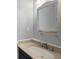 Bathroom featuring dark vanity with modern countertop and a decorative mirror at 7852 S Logan St, Littleton, CO 80122