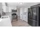 Modern kitchen featuring stainless steel appliances, white cabinets, quartz countertops, and hardwood floors at 7852 S Logan St, Littleton, CO 80122