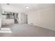 Open living room with staircase and kitchen in view featuring neutral carpeting at 7852 S Logan St, Littleton, CO 80122