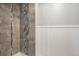 Modern shower with gray tiles and decorative accents, highlighting updated features at 7852 S Logan St, Littleton, CO 80122
