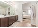 Bright bathroom with double sinks, vanity, and view to bedroom at 9862 Reunion Pkwy, Commerce City, CO 80022