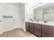 Bright bathroom with double sinks, vanity, and wood-look vinyl plank flooring at 9862 Reunion Pkwy, Commerce City, CO 80022