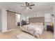 Bedroom featuring ceiling fan, natural light, and rustic sliding door to ensuite at 9862 Reunion Pkwy, Commerce City, CO 80022