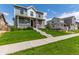 Beautiful home with a manicured lawn and inviting front porch at 9862 Reunion Pkwy, Commerce City, CO 80022