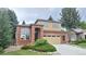 Charming two-story home featuring a brick facade, manicured lawn, and an attached two-car garage at 10538 Tiger Chase, Lone Tree, CO 80124