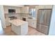 Modern kitchen boasts stainless steel appliances, white cabinets, and a stone island for ample counter space at 10538 Tiger Chase, Lone Tree, CO 80124